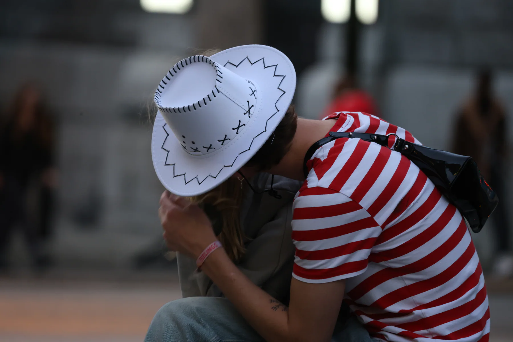 Two people sharing a quiet embrace at a public gathering