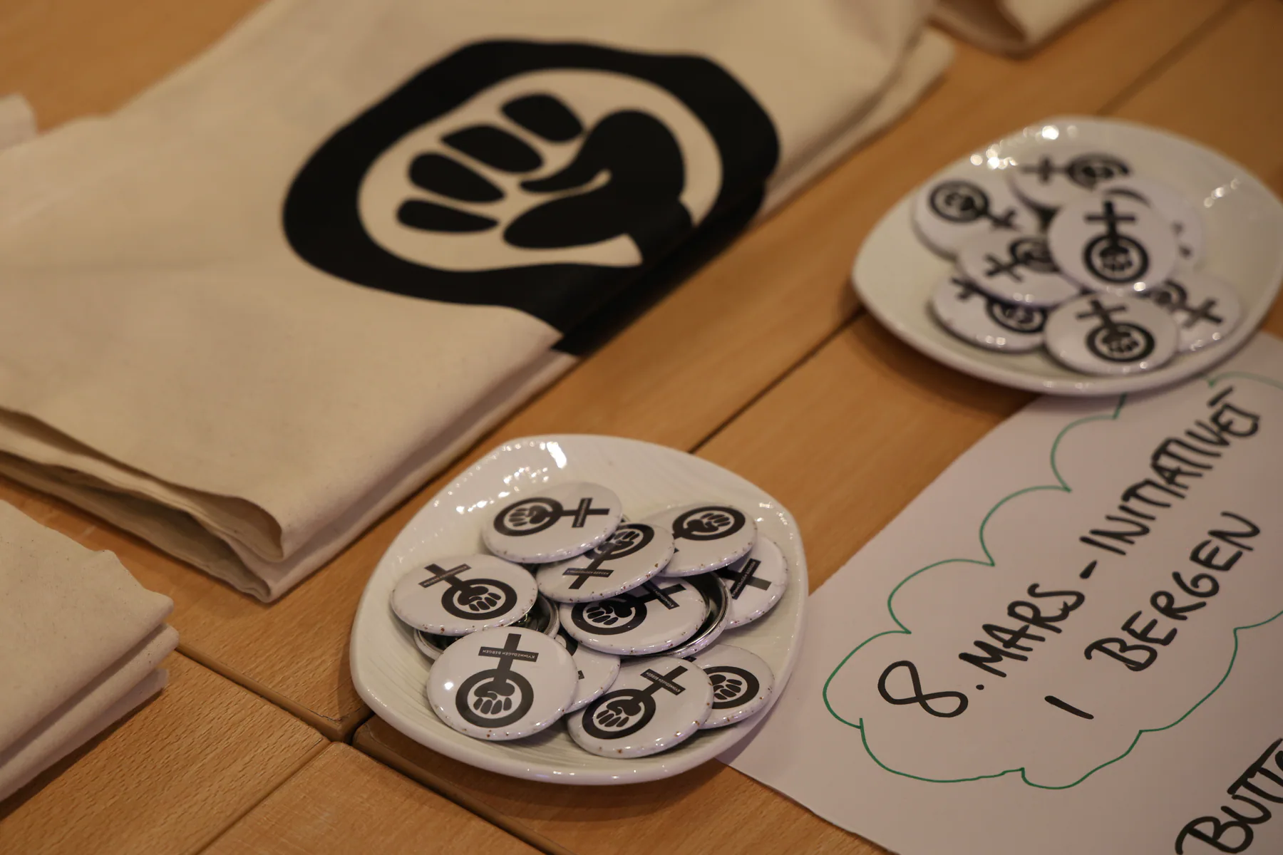 Canvas bags and equality badges arranged for an International Women’s Day event